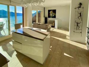 a kitchen and living room with a view of the ocean at EnjoyIseoLake - Corinto - wonderful Lake front apartment in Parzanica