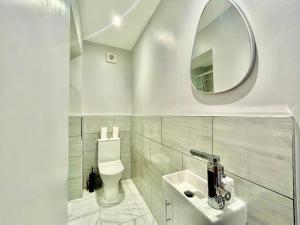 a white bathroom with a toilet and a mirror at 6 Bedroom House -Sleeps 12- Big Savings on Long Stays!! in Ipswich