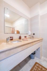 La salle de bains est pourvue d'un lavabo et d'un grand miroir. dans l'établissement Appt charmant, cœur d'Agdal., à Rabat
