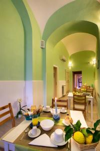 una sala da pranzo con tavolo e cibo di Il Giardino di Tonia - Oplontis Guest House - Bed & Garden - a Torre Annunziata