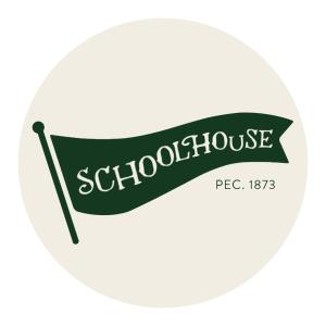 um sinal para uma escola com um cartaz verde em The Schoolhouse PEC + Sandbanks Parking Pass em Demorestville