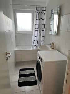 La salle de bains blanche est pourvue d'un lave-linge et d'un lavabo. dans l'établissement Bruchköbel 3 auch für Monteure, à Bruchköbel