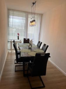 une salle à manger avec une table, des chaises et un lustre dans l'établissement Bruchköbel 3 auch für Monteure, à Bruchköbel