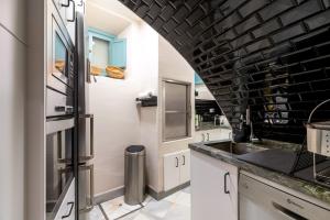 a kitchen with white cabinets and a black brick wall at Casa Guadalupe in Seville