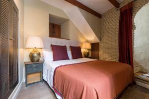 a bedroom with a large bed with purple pillows at Hotel La Casa del Califa in Vejer de la Frontera