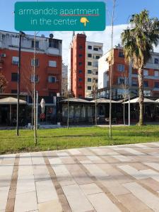 a park with buildings and a sign that reads emergency apartment in the center at Armando's apartment in the center in Durrës