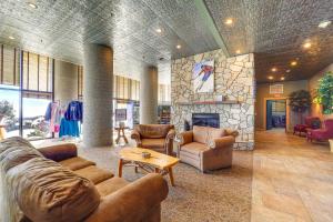 a living room with couches and a stone fireplace at Pool & Hot Tub: Mtn-View Condo in Sugartop Resort! in Sugar Mountain