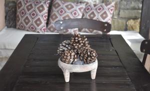 a wooden table with pine cones in a bowl on it at Anemos Holiday Houses - Unterkunft in Südkreta in Keratokampos