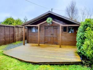 a house with a wooden deck in front of it at Forest View Cabin in Ballaghaderreen