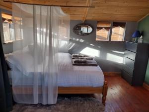a bedroom with a bed with white sheets and a mirror at Forest View Cabin in Ballaghaderreen