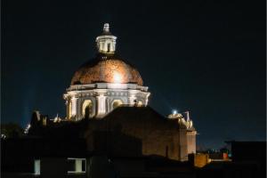 a building with a dome on top of it at night at OYO Hotel Casona Poblana in Puebla