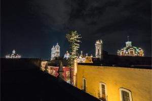 a tree on the roofs of buildings at night at OYO Hotel Casona Poblana in Puebla