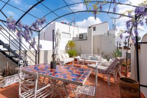 a patio with a table and chairs at Casa Guadalupe in Seville