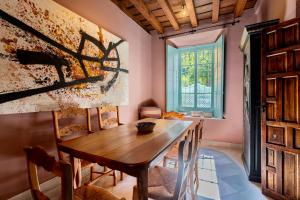 uma sala de jantar com uma mesa de madeira e cadeiras em Casa Guadalupe em Sevilha