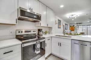 a kitchen with white cabinets and a stove top oven at Fort Pierce Rental with Pool Access - Walk to Beach! in Fort Pierce