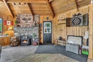 a living room with a stone fireplace and a door at Entire cottage in Algonquin Highlands Canada in Algonquin Highlands