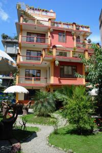a large pink building with a garden in front of it at Elbrus Home in Kathmandu