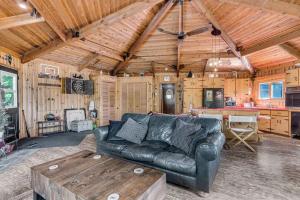 a living room with a leather couch and a table at Entire cottage in Algonquin Highlands Canada in Algonquin Highlands