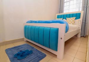 a bedroom with a blue and white bed and a blue rug at FOREVER 3 RESIDENCE in Naivasha