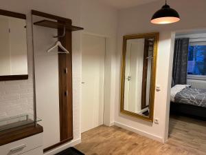 een kamer met een spiegel en een slaapkamer met een bed bij Wunderschöne Ferienwohnung mit Balkon auf dem Bauernhof in Greven
