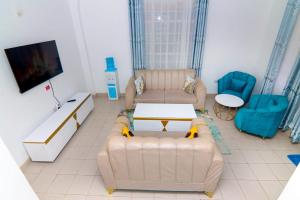 a living room with two couches and a tv at FOREVER 3 RESIDENCE in Naivasha