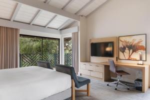 a bedroom with a bed and a desk and a television at Pala Mesa Resort in Fallbrook