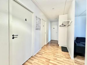 a hallway with a white door and a blue couch at DownTown Rooms And Sauna in Helsinki