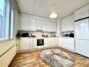a kitchen with white cabinets and a large window at DownTown Rooms And Sauna in Helsinki