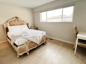 a bedroom with a bed and a window and a desk at Victory House in Burnaby