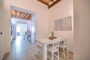 uma sala de jantar branca com uma mesa e cadeiras brancas em San Niccolò Luxury Apartment em Florença