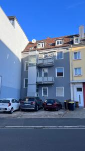 3 Zimmer Apartment mit Parkplatz - Sleepomat في أشافنبورغ: مجموعة سيارات متوقفة أمام مبنى