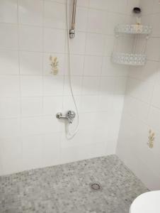 El baño incluye ducha blanca con grifo. en Room in Shared apartment with Parking, en Almuñécar