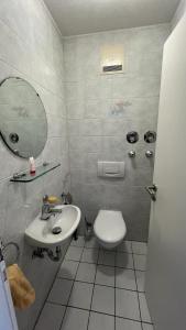 ein Badezimmer mit einem Waschbecken, einem WC und einem Spiegel in der Unterkunft Lisa's Ferienwohnung in Obing