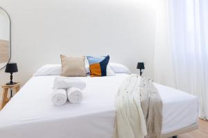 a bedroom with a white bed with two towels on it at BILBAO NORTH SHORE APARTMENTS 2 in Bilbao