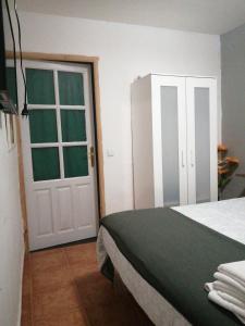 1 dormitorio con cama y puerta blanca en Reposo tranquilo en entorno rural, en Cetina