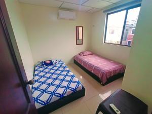 een kamer met 2 bedden en een raam bij Suite Ejecutiva 3dorms 1-8personas seguridad24h piscina in Guayaquil