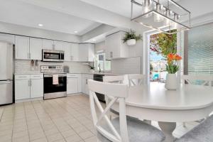 uma cozinha branca com uma mesa de jantar branca em Charming Largo Home with Private Pool 1 Mi to Beach em Largo