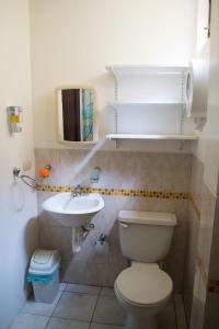 y baño con aseo y lavamanos. en Suite Dpto 3dorms 6 camas 1-9personas seguridad24h piscina en Guayaquil