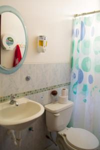 een badkamer met een toilet, een wastafel en een spiegel bij Suite Ejecutiva 3dorms 1-8personas seguridad24h piscina in Guayaquil