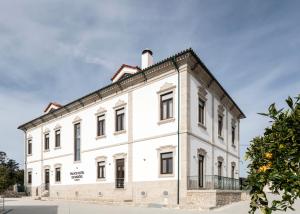 a large white building on a street at Palace Hotel de Midões in Midões