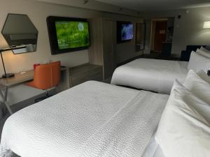 ein Hotelzimmer mit 2 Betten, einem Schreibtisch und einem TV in der Unterkunft Holiday Inn Express Birmingham Irondale East, an IHG Hotel in Birmingham