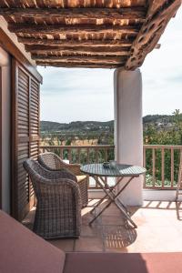 a patio with two chairs and a table on a balcony at ES CUCONS RURAL HOTEL in San Antonio