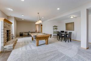 a living room with a pool table and a fireplace at Spacious Pool House with tons of amenities! in Omaha