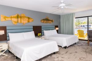 twee bedden in een kamer met een vis aan de muur bij Lakehouse Resort in San Marcos