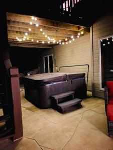 a room with a hot tub with stairs and lights at Spacious Pool House with tons of amenities! in Omaha