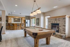 a pool table in a living room with a fireplace at Spacious Pool House with tons of amenities! in Omaha