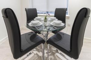 a glass table with four black chairs around it at OPP Exeter LH11 - Behind the Cathedral with free parking! BIG SAVINGS booking 7 nights or more! in Exeter