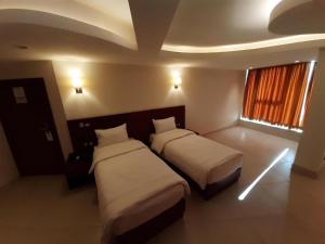 卡爾巴拉的住宿－Coral Hotel Karbala，酒店客房设有两张床和窗户。
