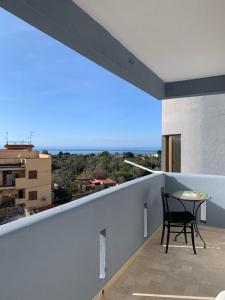 a black chair sitting on a balcony with a table at Blumare in Capaci