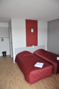 Relais de Barbezieux في باربيزيو: غرفة نوم بسرير احمر واريكة حمراء
